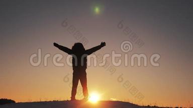 男子游客举起双手，成功胜利站在山顶上剪影的冬天。 黎明日出